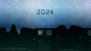 2024 Yeni Yıl kelimesi eski bir daktiloyla bir kağıt üzerinde daktilo yazıyor..