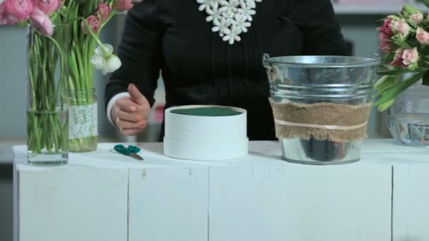 Woman making a flower arrangement in the round form white box — Stock video