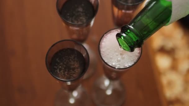 Шампанское, разливающееся из бутылки в четыре бокала — стоковое видео