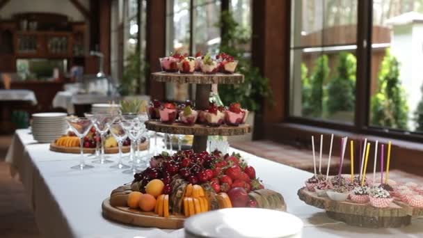 Deliciosos dulces y frutas decoradas en mesas, cócteles fiesta catering — Vídeo de stock