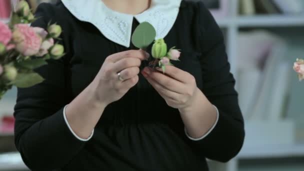 Un florista hace un pequeño ramo — Vídeos de Stock