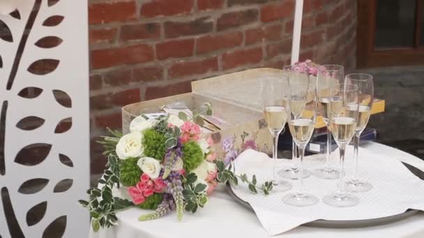 Стол для свадебной церемонии с бокалом шампанского и коробкой поздравлений — стоковое видео