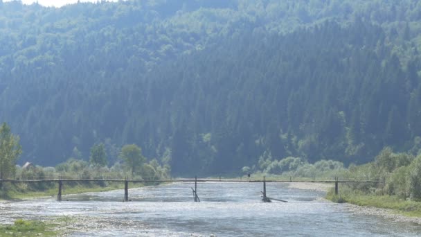 Muž jít hory řeka na mostě — Stock video