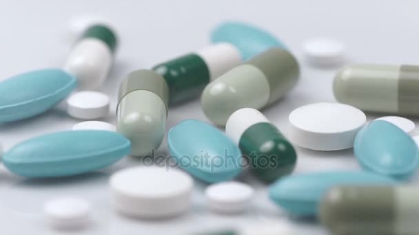 Pílulas verdes brancas giram sobre um fundo branco — Vídeo de Stock