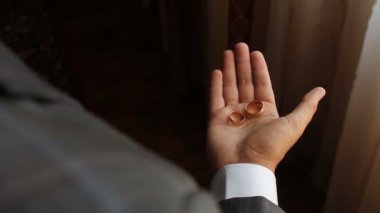 adam iki altın yüzük onun avuç içi gösterir, daha sonra eline bir yumruk sıkarak