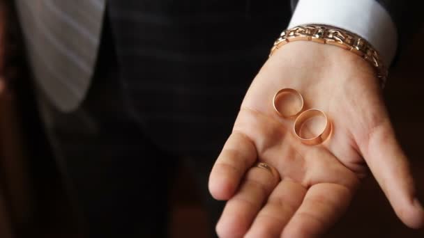 The hand squeezes wedding rings in a fist — Stock Video