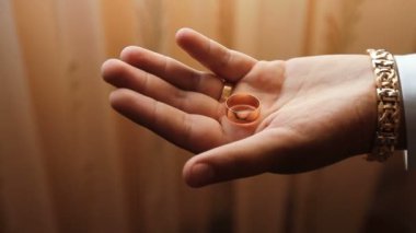 el alyans içinde bir yumruk sıkarak.