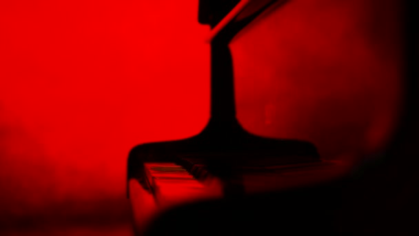 Um pianista fecha uma tampa para o piano, fundo vermelho — Vídeo de Stock