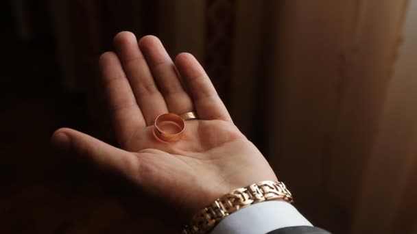 La mano aprieta los anillos de boda en un puño — Vídeo de stock