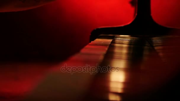 Ένας πιανίστας ανοίγει ένα καπάκι στο πιάνο και αρχίζει να παίζει σε κόκκινο φόντο κίτρινο — Αρχείο Βίντεο