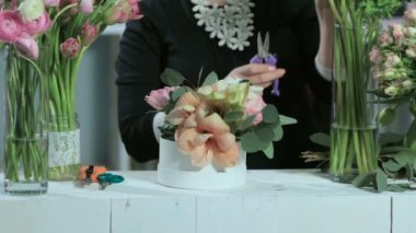 Çiçekçi Çiçek keser, beyaz masasına çiçek buketleri