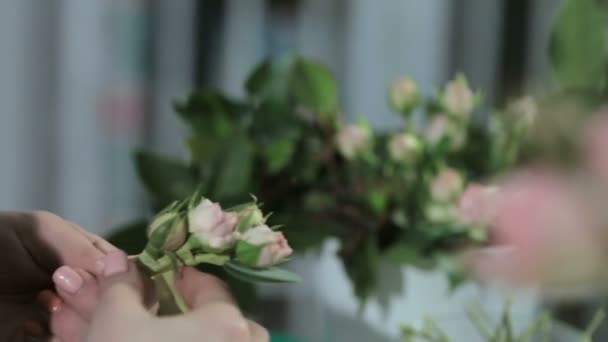 Флорист делает корону из маленьких роз, крупным планом — стоковое видео