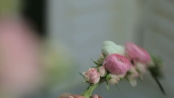 Флорист делает корону из маленьких роз, крупным планом — стоковое видео