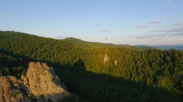 Mongolfiera volare attraverso il cielo in un paesaggio di montagne vicino alle rocce — Video Stock