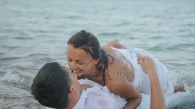 Sarılma ve öpüşme denizde yatan genç Çift