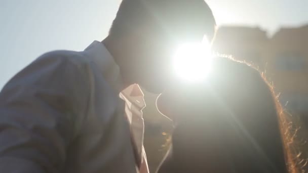 Молодая влюбленная пара целуется на солнце — стоковое видео