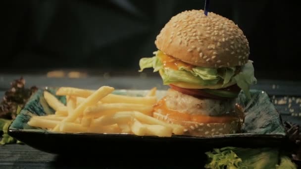 Жареный картофель падает на гамбургер, фаст-фуд — стоковое видео