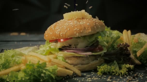 Comida jugosa de hamburguesa de res con tocino y queso, ensalada servida con papas fritas crujientes — Vídeo de stock