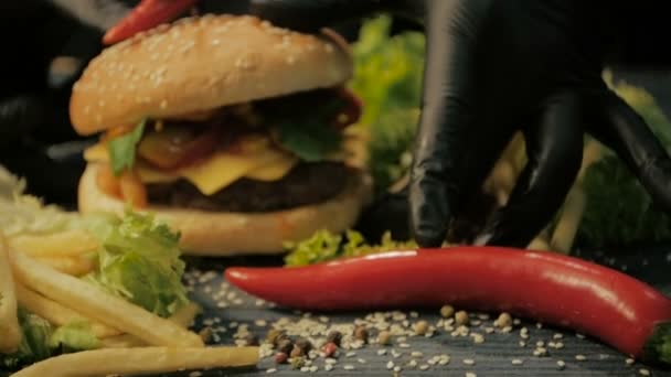 Tasty burger is great on a wooden tray. A man takes his hands, dolly shot — Stock Video