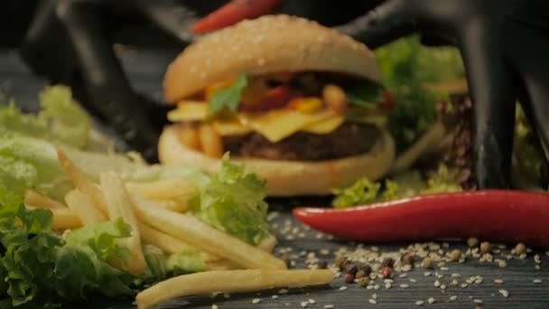 Chutné burger je skvělý na dřevěný tác. Muž vezme ruce, dolly shot — Stock video