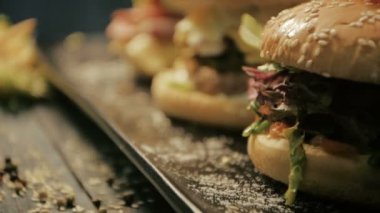 Hamburger çizburger etli sığır eti ve taze salata malzemelerin rustik ahşap bir masa üzerine. yakın çekim