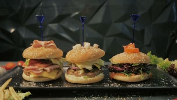 Set hamburgers met vis, vlees en groenten. Bovenaanzicht. Op een houten ondergrond, dolly schot — Stockvideo