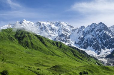 Zümrüt yamaçları ve dik yüz ile dağ manzarası