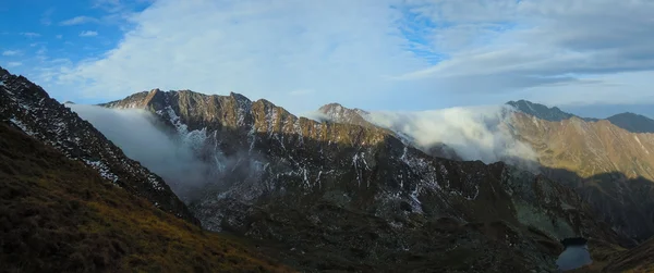 Panoramisch uitzicht op steile bergen met wolken — Stockfoto