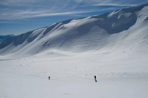 Два туриста двигаются по снежному плато — стоковое фото
