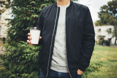 Kahve tutan adam parkta yürürken gitmek