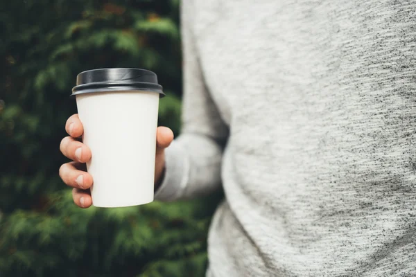 Bir fincan kahve parkta tutan adam