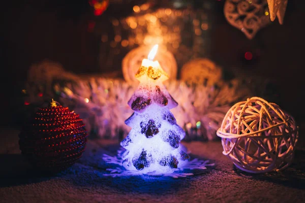 Kerze und Spielzeug in der Nähe von Weihnachtsbaum — Stockfoto