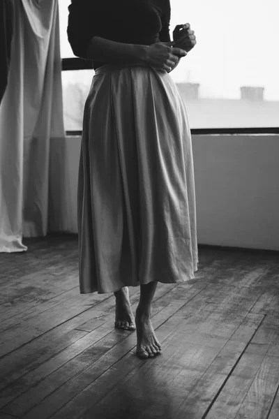 Krásná žena v bílých šatech na dřevěné podlaze stojí — Stock fotografie