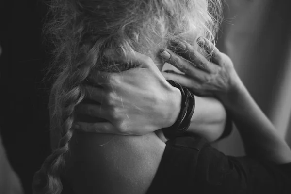 La niña se sostiene con dos manos detrás del cuello de cerca. Blanco y negro — Foto de Stock