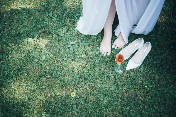 पांढर्या ड्रेसमध्ये सुंदर तरुण स्त्री लग्नाच्या दिवशी स्वत: ला तयार करते आणि तिच्या पायावर गारमेंट घालते. वधू सकाळी तपशील . — स्टॉक फोटो, इमेज