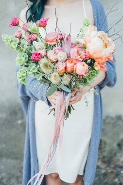 Dekoratif bir buket çiçek onun elinde tutan bir kadın