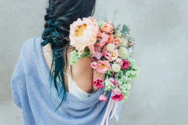 Dekoratif bir buket çiçek onun elinde tutan bir kadın