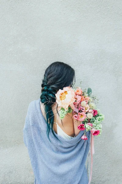 Renkli çiçek bir demet uzanmış elinde tutan bir kadın