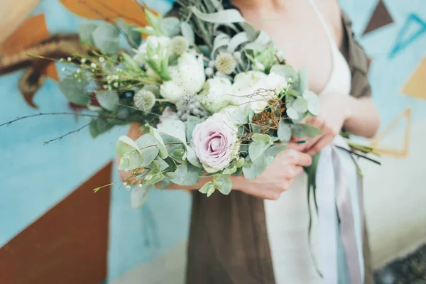 Dekoratif bir buket çiçek onun elinde tutan bir kadın