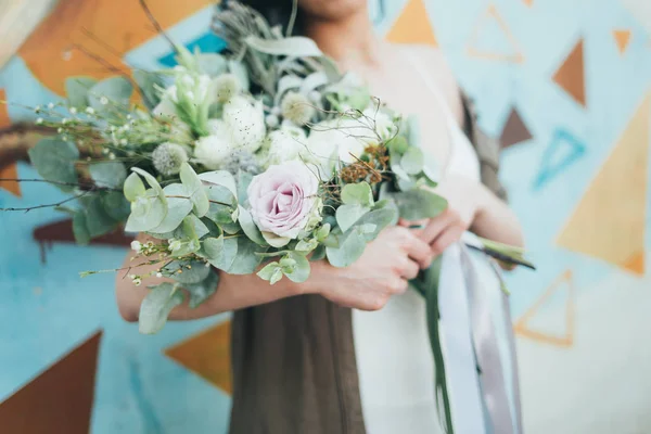 Renkli çiçek bir demet uzanmış elinde tutan bir kadın