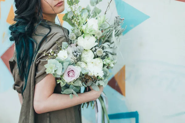 Kadın bir bahar çiçek buketi tutar