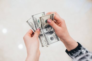 Kız elinde dolar tutar.