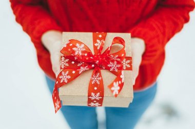 Kız bir Noel hediyesi onun elinde tutar.