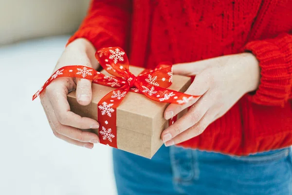 Kız bir Noel hediyesi onun elinde tutar.