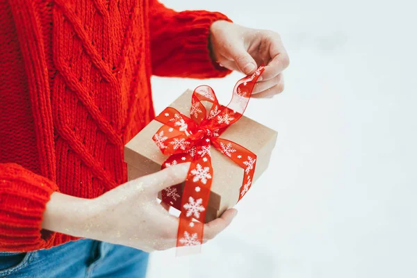 Kız bir Noel hediyesi onun elinde tutar.