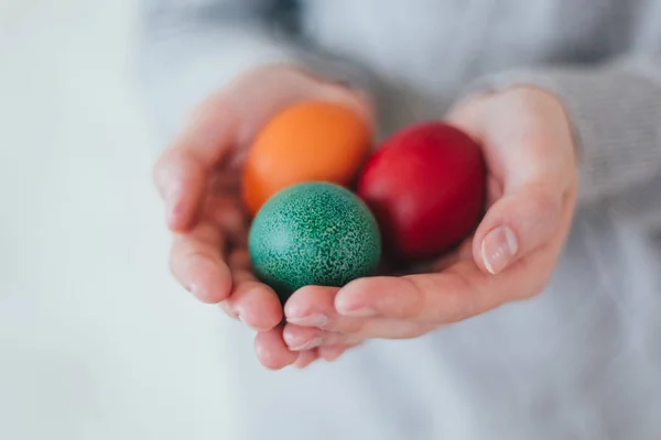 Руки, що тримають сучасні великодні яйця, пофарбовані в барвисті . — стокове фото