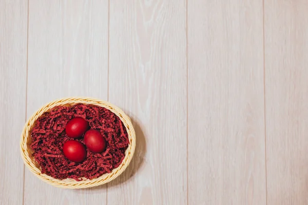 Yuvaya alan ahşap zemin üzerine kırmızı Paskalya yortusu yumurta.