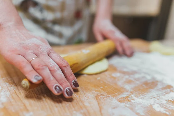 Handen bakken deeg met deegroller op houten tafel — Stockfoto