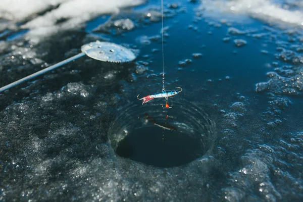 Pesca de inverno, haste de pesca fica no buraco à espera do peixe — Fotografia de Stock