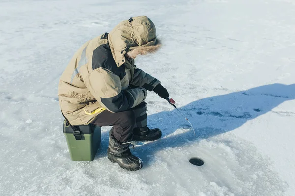 Pesca de inverno, haste de pesca fica no buraco à espera do peixe — Fotografia de Stock